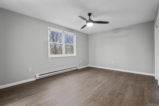 spare room featuring ceiling fan, baseboard heating, wood finished floors, and baseboards