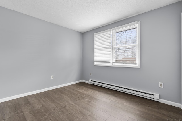 empty room with baseboards, a textured ceiling, baseboard heating, and wood finished floors