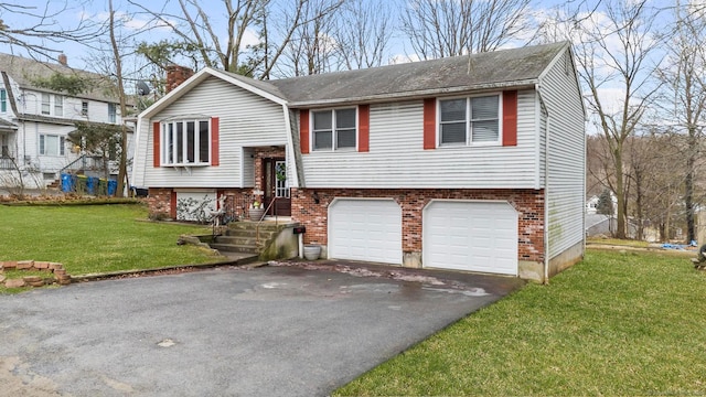 bi-level home featuring brick siding, a chimney, an attached garage, a front yard, and driveway