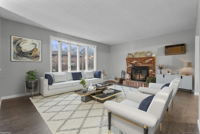 living room with a fireplace, an AC wall unit, a textured ceiling, wood finished floors, and baseboards