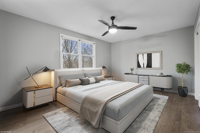 bedroom with radiator, baseboards, and wood finished floors