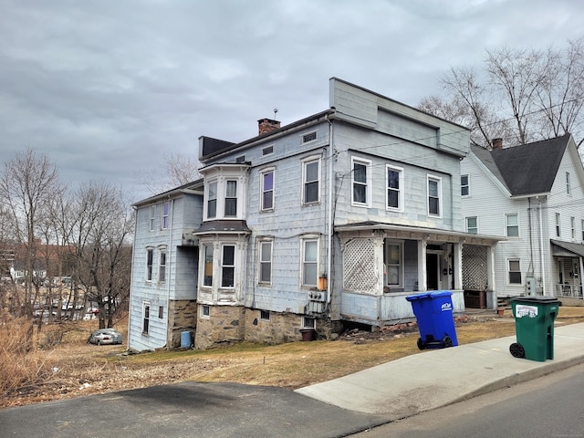 view of front of home featuring a chimney and central AC unit