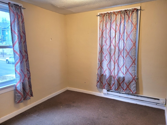 unfurnished room featuring dark carpet, a textured ceiling, and baseboards