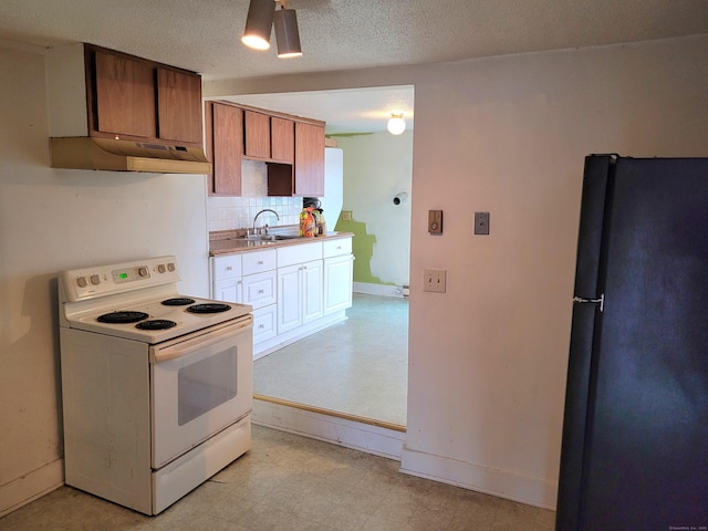 kitchen featuring white electric stove, freestanding refrigerator, under cabinet range hood, light floors, and a sink