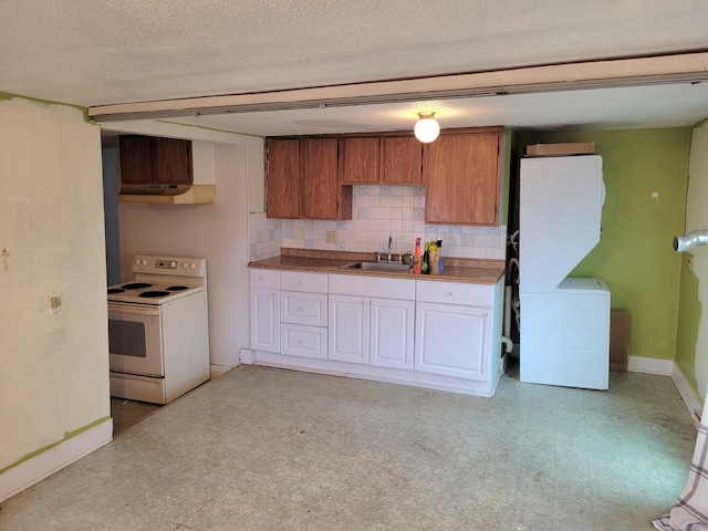 kitchen with under cabinet range hood, white electric range, a sink, light floors, and washer / dryer