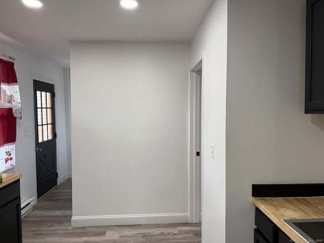 kitchen featuring light wood-type flooring, baseboards, a baseboard heating unit, and recessed lighting