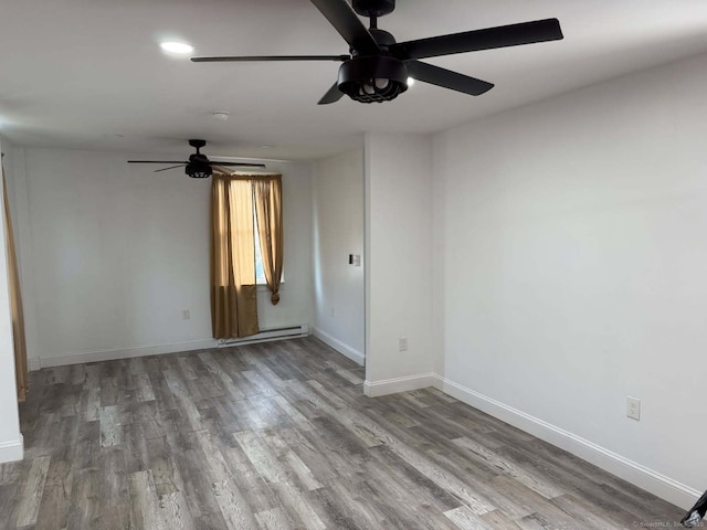 spare room with a baseboard heating unit, wood finished floors, baseboards, and ceiling fan