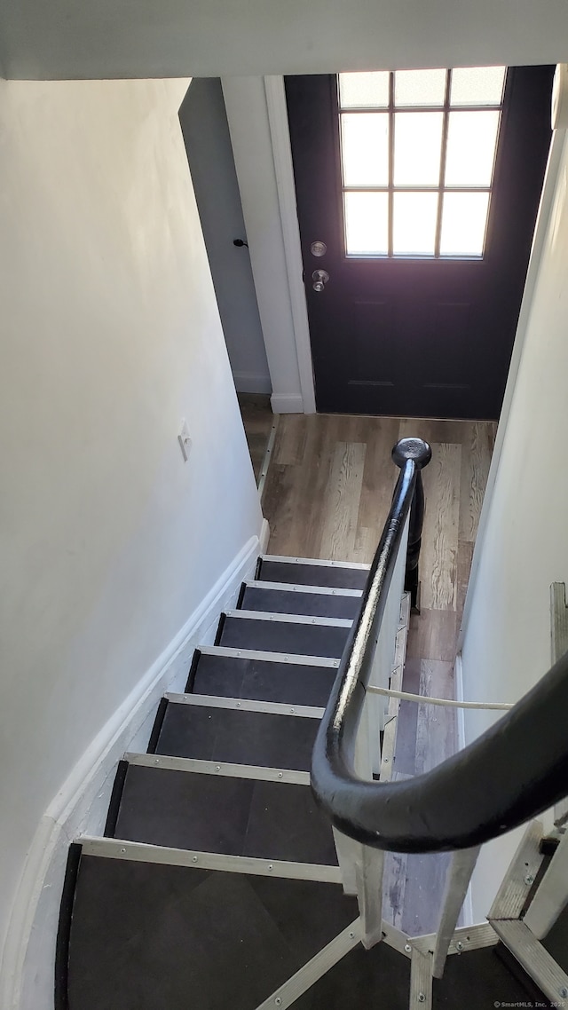 stairs with baseboards and wood finished floors