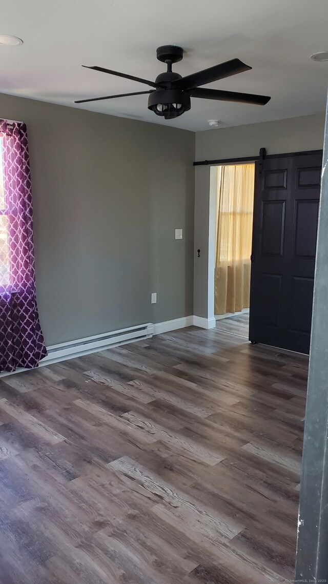 unfurnished room with baseboards, wood finished floors, a baseboard heating unit, and ceiling fan