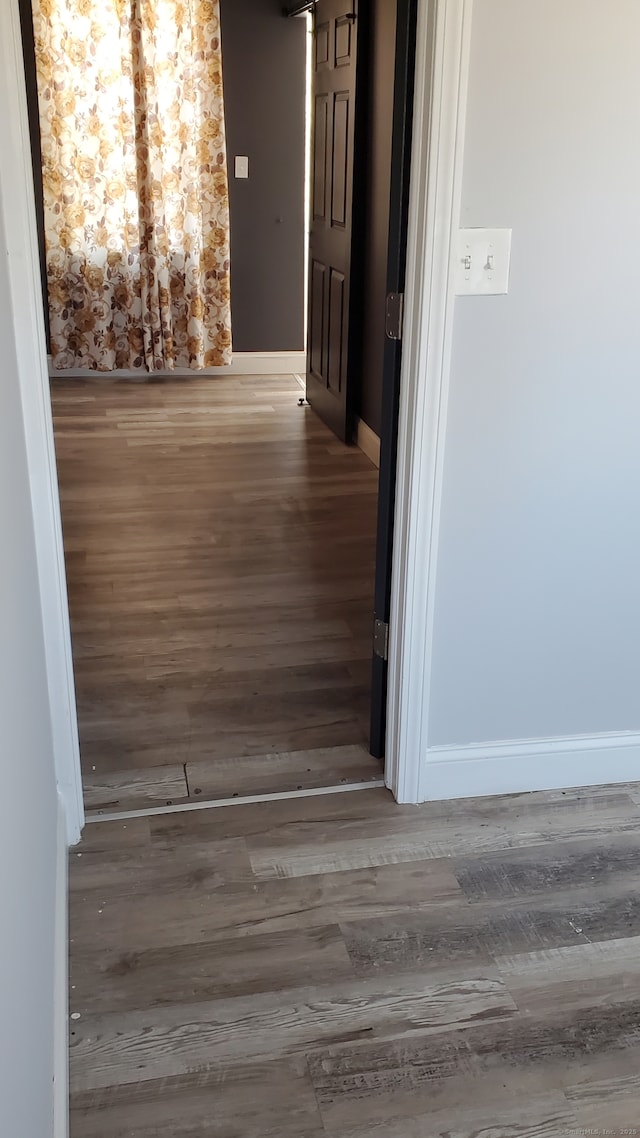 hall featuring wood finished floors and baseboards
