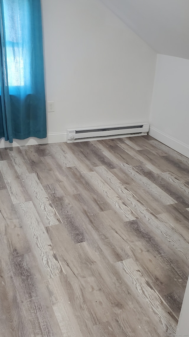 interior space with a baseboard radiator, baseboards, and wood finished floors