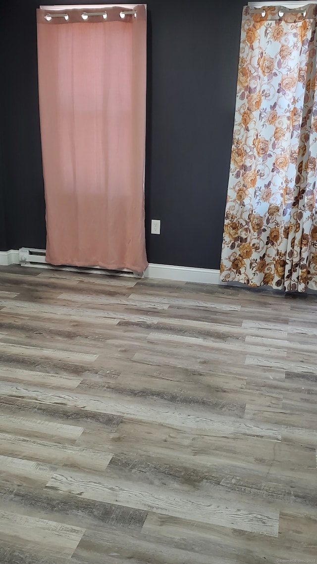 unfurnished room with baseboards and wood finished floors