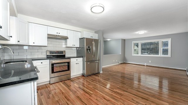 kitchen with white cabinets, stainless steel appliances, light wood-type flooring, under cabinet range hood, and a sink