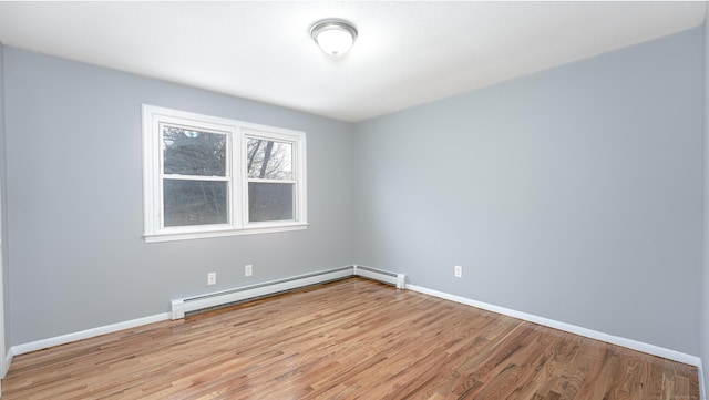 empty room with light wood-type flooring, baseboards, and baseboard heating