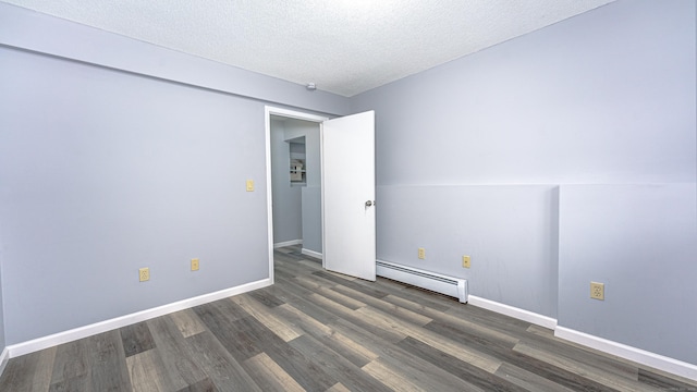 spare room with a textured ceiling, baseboards, baseboard heating, and wood finished floors