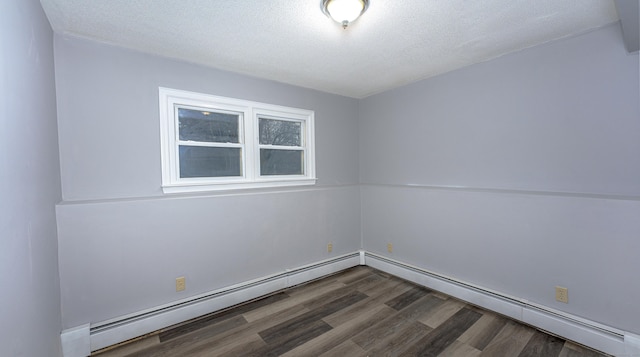 empty room with a baseboard heating unit, a textured ceiling, and wood finished floors