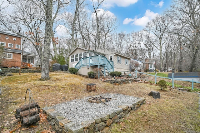 view of front of property with an outdoor fire pit, a deck, and stairs