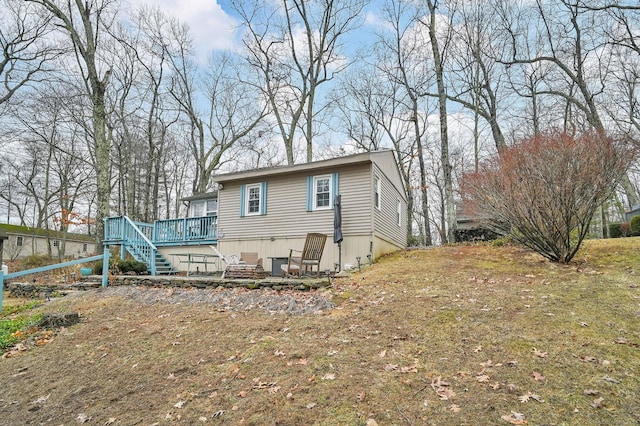 rear view of property with stairway and a deck