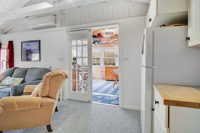 living area featuring lofted ceiling with beams, wood ceiling, carpet floors, and an AC wall unit