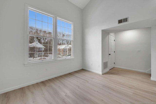 spare room with visible vents, baseboards, and wood finished floors