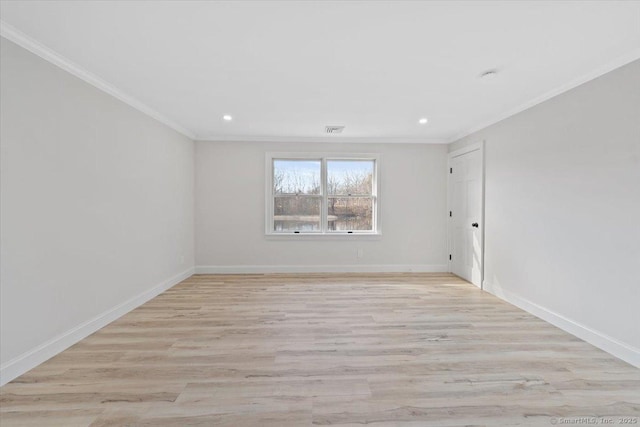 spare room featuring baseboards, light wood-type flooring, and crown molding