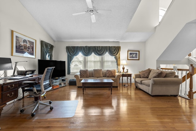 home office with ceiling fan, a textured ceiling, vaulted ceiling, and wood finished floors