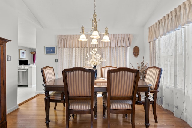 dining room with vaulted ceiling, light wood-style floors, plenty of natural light, and an inviting chandelier