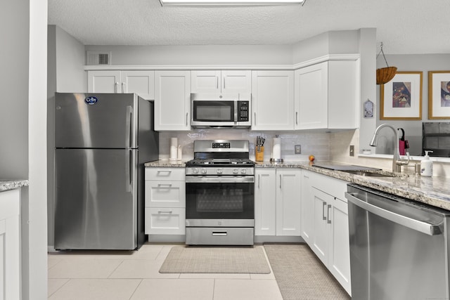 kitchen featuring white cabinetry, visible vents, stainless steel appliances, and a sink