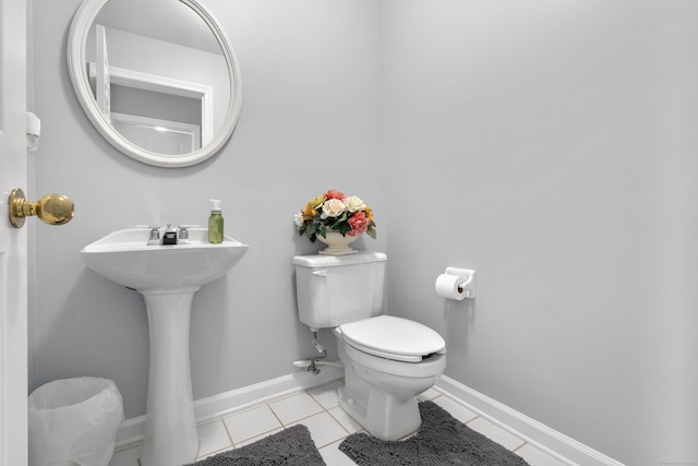 half bath featuring tile patterned flooring, baseboards, and toilet