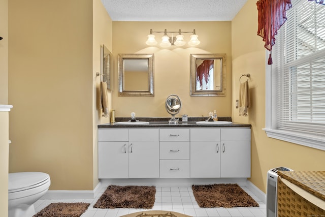 full bathroom featuring a textured ceiling, a sink, and tile patterned floors