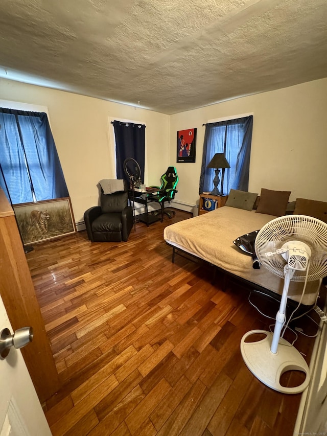 bedroom with a textured ceiling and wood finished floors