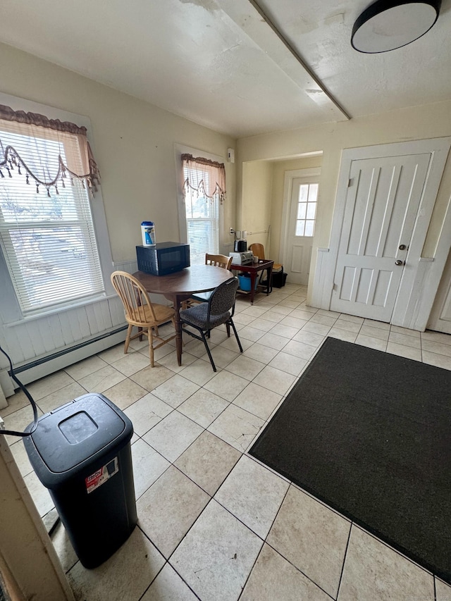 dining space with a baseboard radiator and light tile patterned flooring