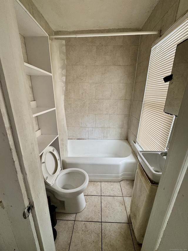 bathroom with shower / tub combo, a sink, toilet, and tile patterned floors