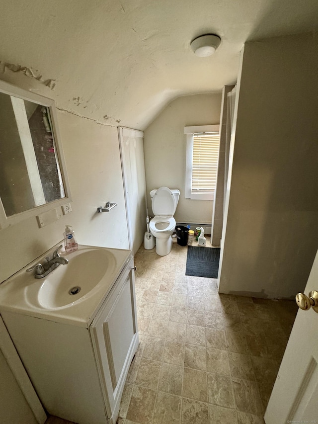 bathroom featuring vaulted ceiling, vanity, and toilet