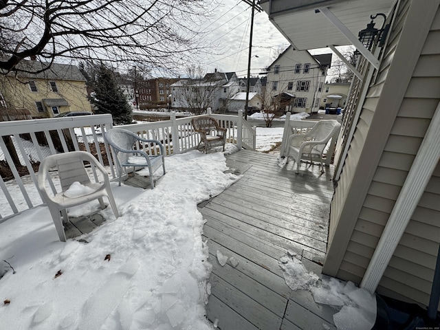 snow covered deck featuring a residential view