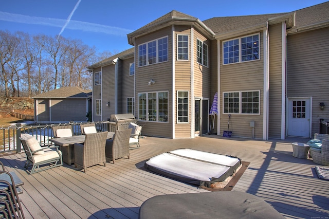 wooden terrace with a grill, outdoor dining area, and an outbuilding