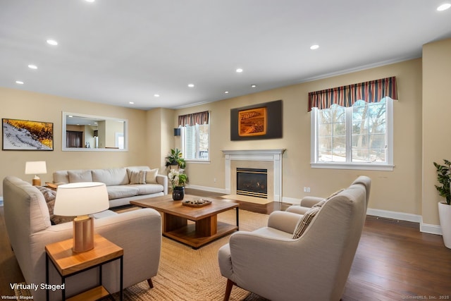 living room with a fireplace with flush hearth, recessed lighting, baseboards, and wood finished floors