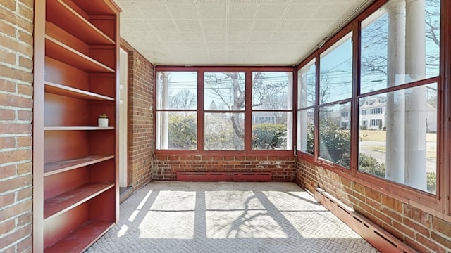 unfurnished sunroom with a wealth of natural light and a baseboard heating unit