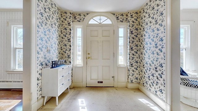 entrance foyer with wallpapered walls, a wealth of natural light, and ornamental molding