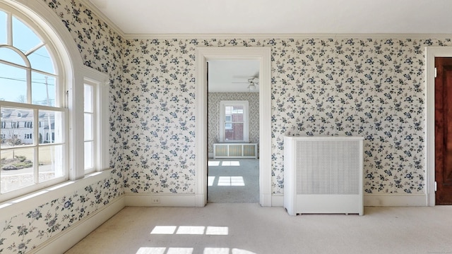 interior space featuring carpet flooring, radiator, and wallpapered walls