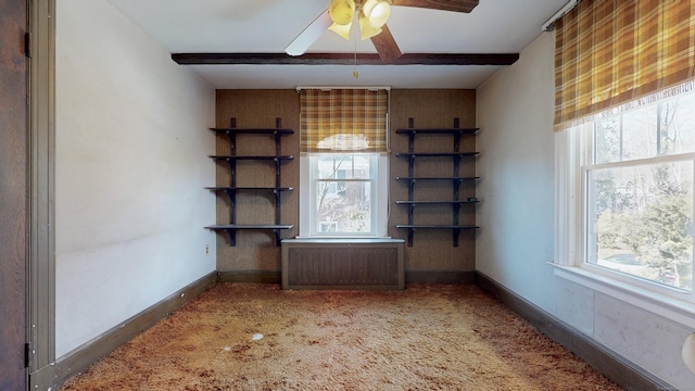 spare room with beam ceiling, ceiling fan, carpet, and baseboards