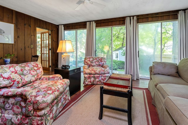 64 Old Kings Hwy S, Darien, CT 06820 - living area with a ceiling fan, healthy amount of natural light, wooden walls, and wood finished floors