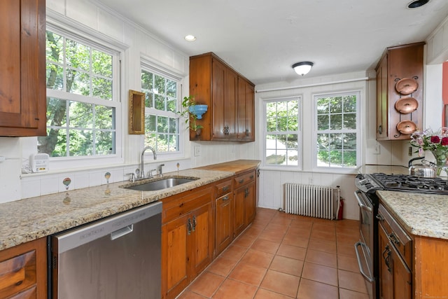 64 Old Kings Hwy S, Darien, CT 06820 - kitchen with radiator heating unit, stainless steel appliances, a sink, brown cabinetry, and light tile patterned floors