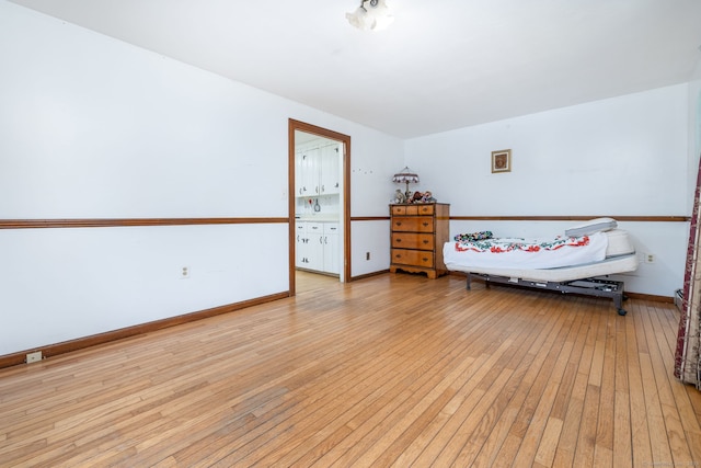 bedroom featuring light wood-style floors and baseboards