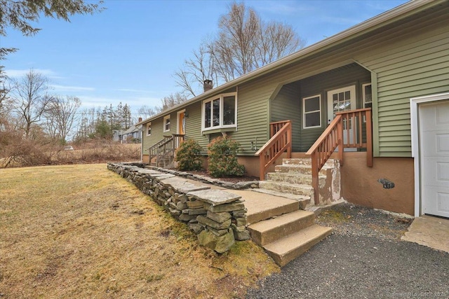 exterior space featuring a garage, a chimney, and a front yard