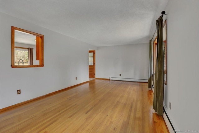 unfurnished living room with light wood-style flooring, baseboard heating, and a textured ceiling