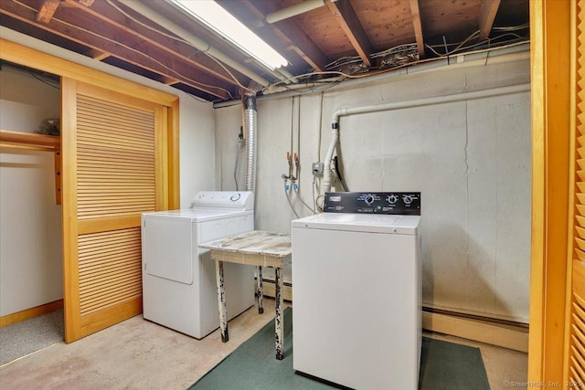 laundry area featuring laundry area, washer and clothes dryer, and baseboard heating