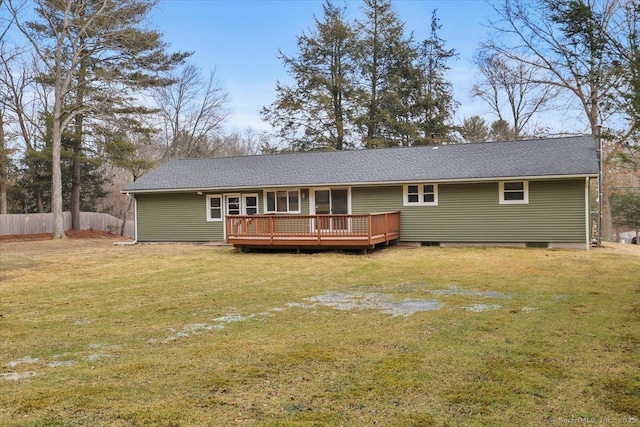 rear view of property featuring a shingled roof, a lawn, fence, and a wooden deck