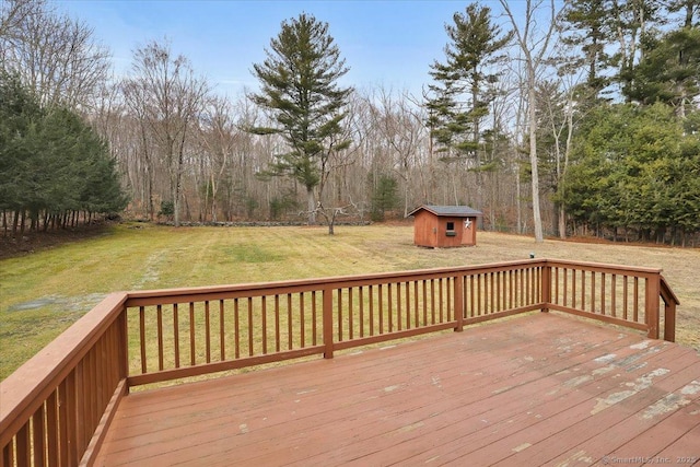 wooden terrace with an outdoor structure, a storage shed, and a lawn