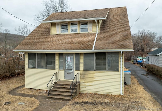 view of front of house featuring a shingled roof and entry steps